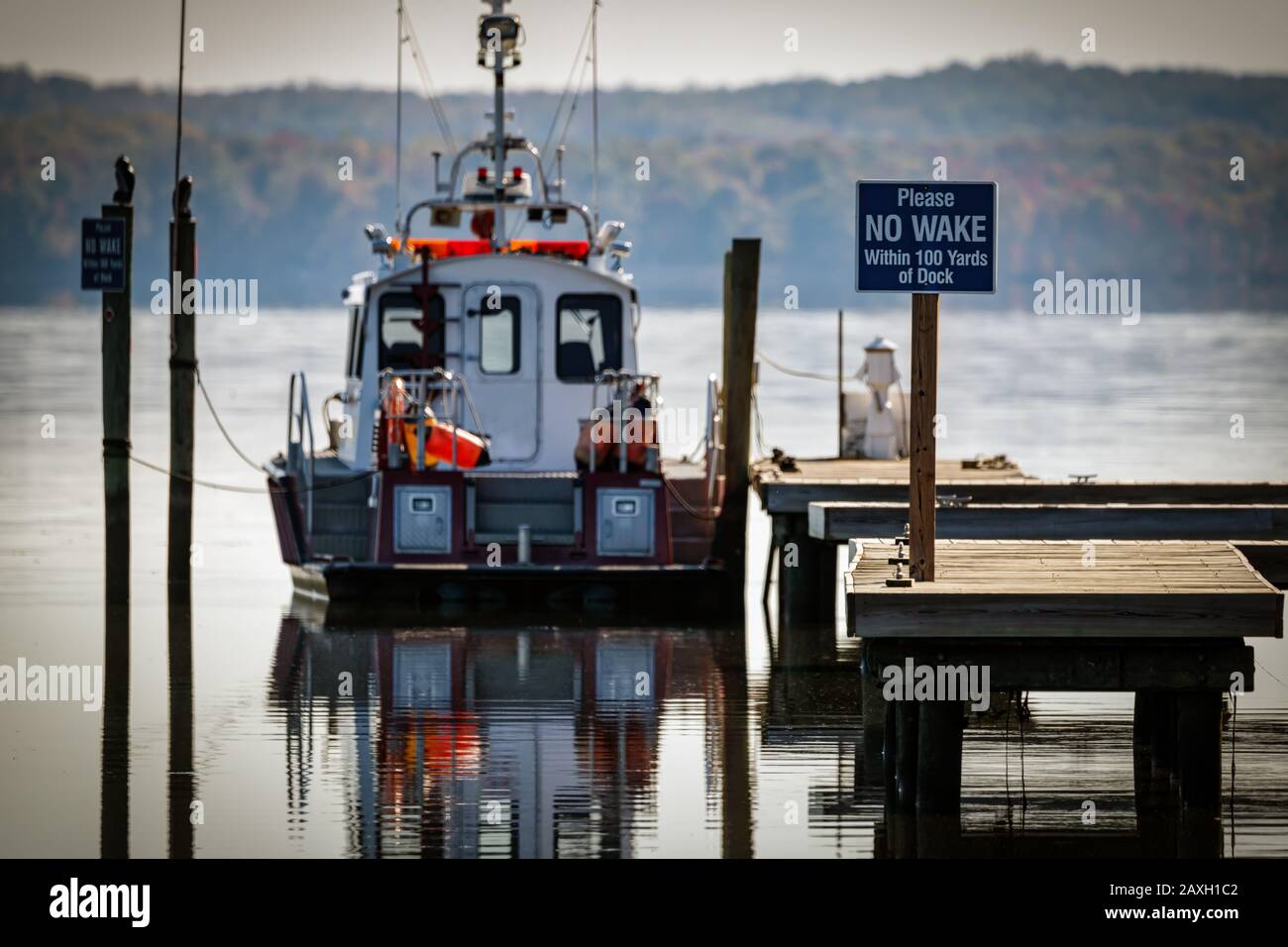 A “no wake” sign on a rescue boat dock at a Potomac River cove in Virginia. Stock Photo