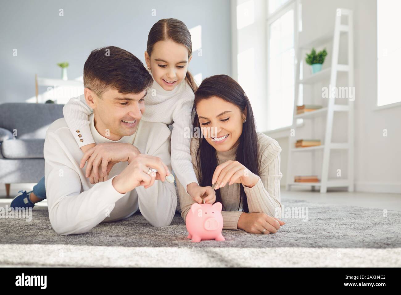 Happy family saves money in a piggy bank pig Stock Photo - Alamy