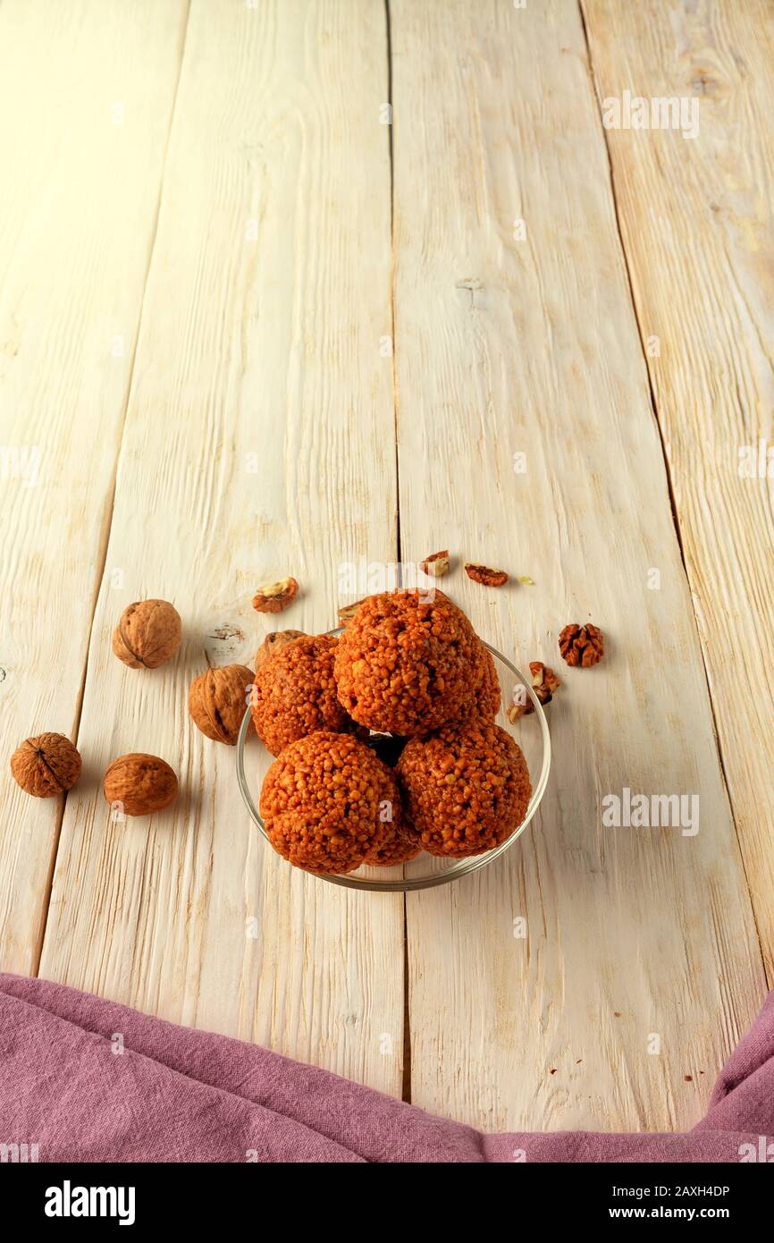 Homemade energy balls with walnuts, peanut, honey and banana on a light wooden surface, top view, vertical image. Stock Photo