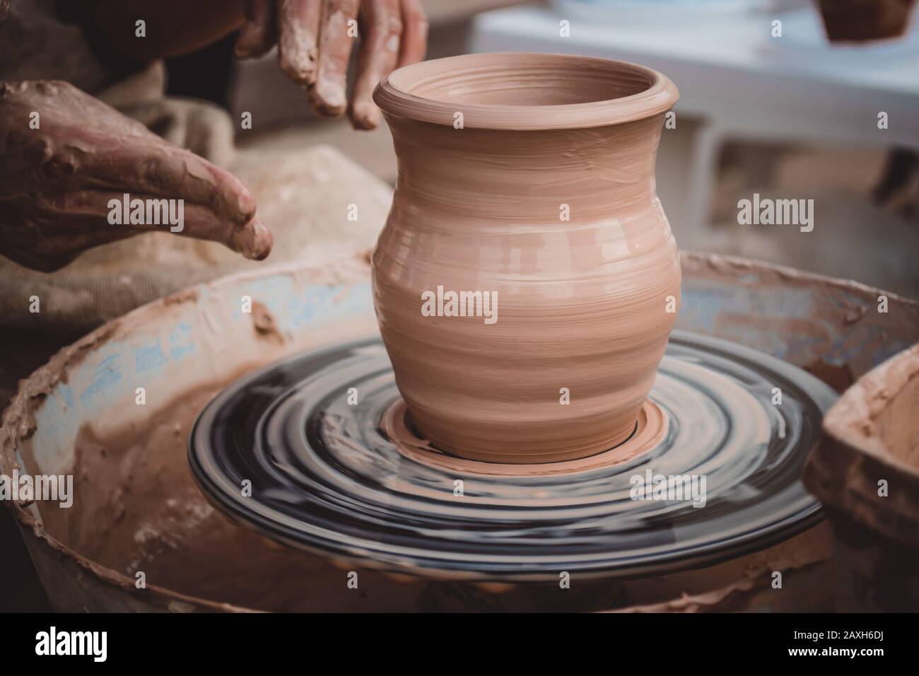 Vase fresh clay potter's wheel. Twisted potter's wheel. Master crock. Stock Photo