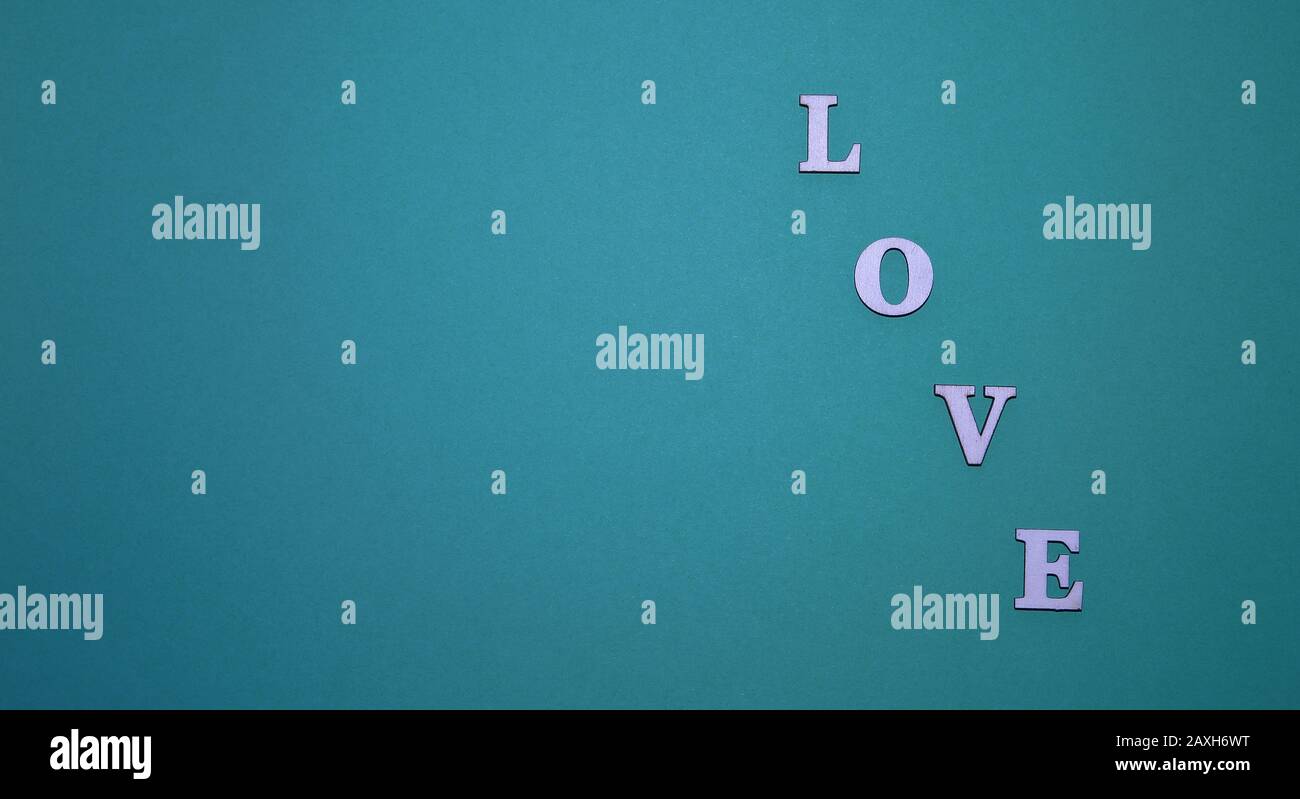 Word LOVE made of decorative wooden made letetrs across blue background Stock Photo