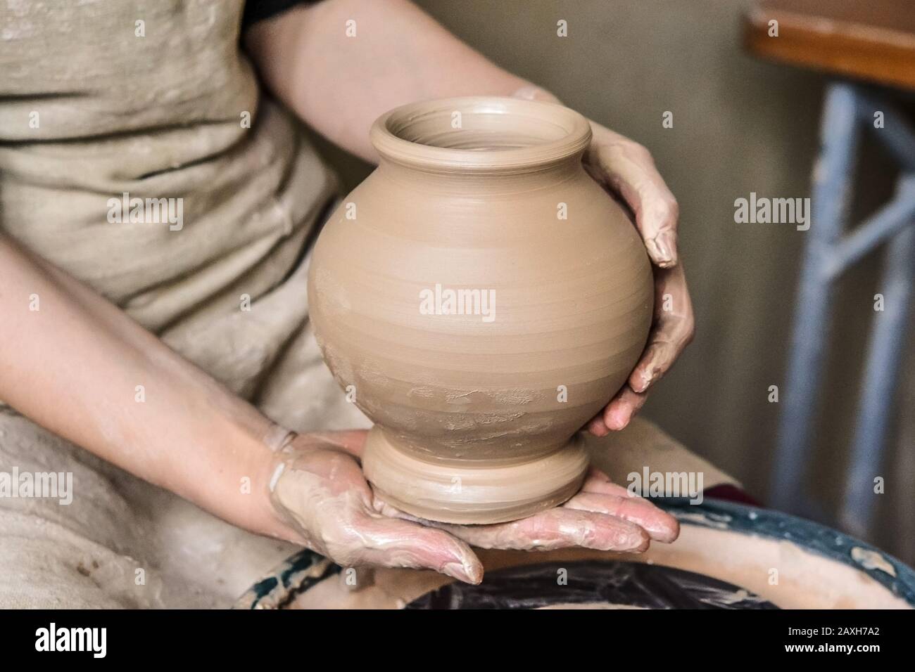 Potter holds just hired by pitcher. Ceramic skills. Sculptor sculpts products from white clay. Workshop pottery.Ukraine, national traditions Stock Photo