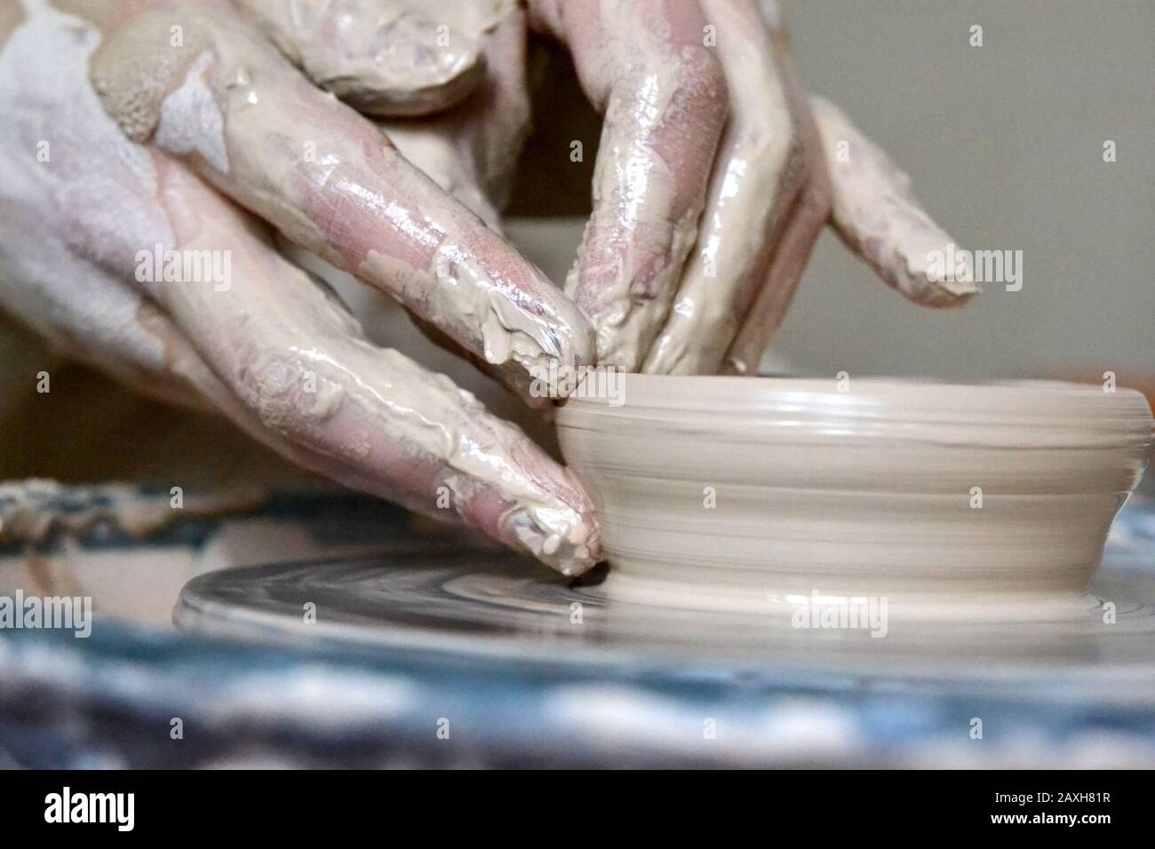 The potter makes clay earthen pot. Soiled hands in the clay and the