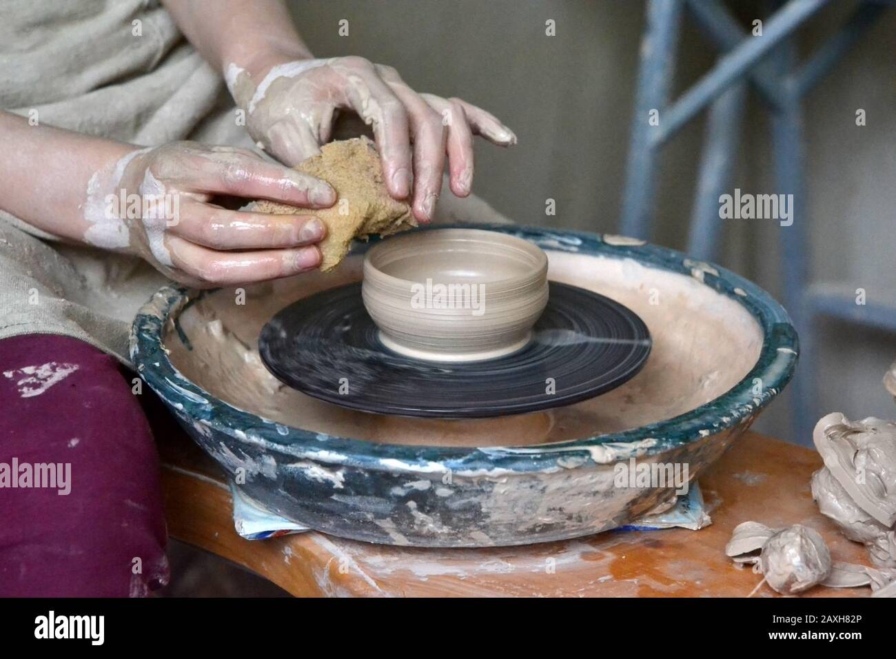 person potter makes clay jug on a potter's wheel in pottery workshop Stock Photo