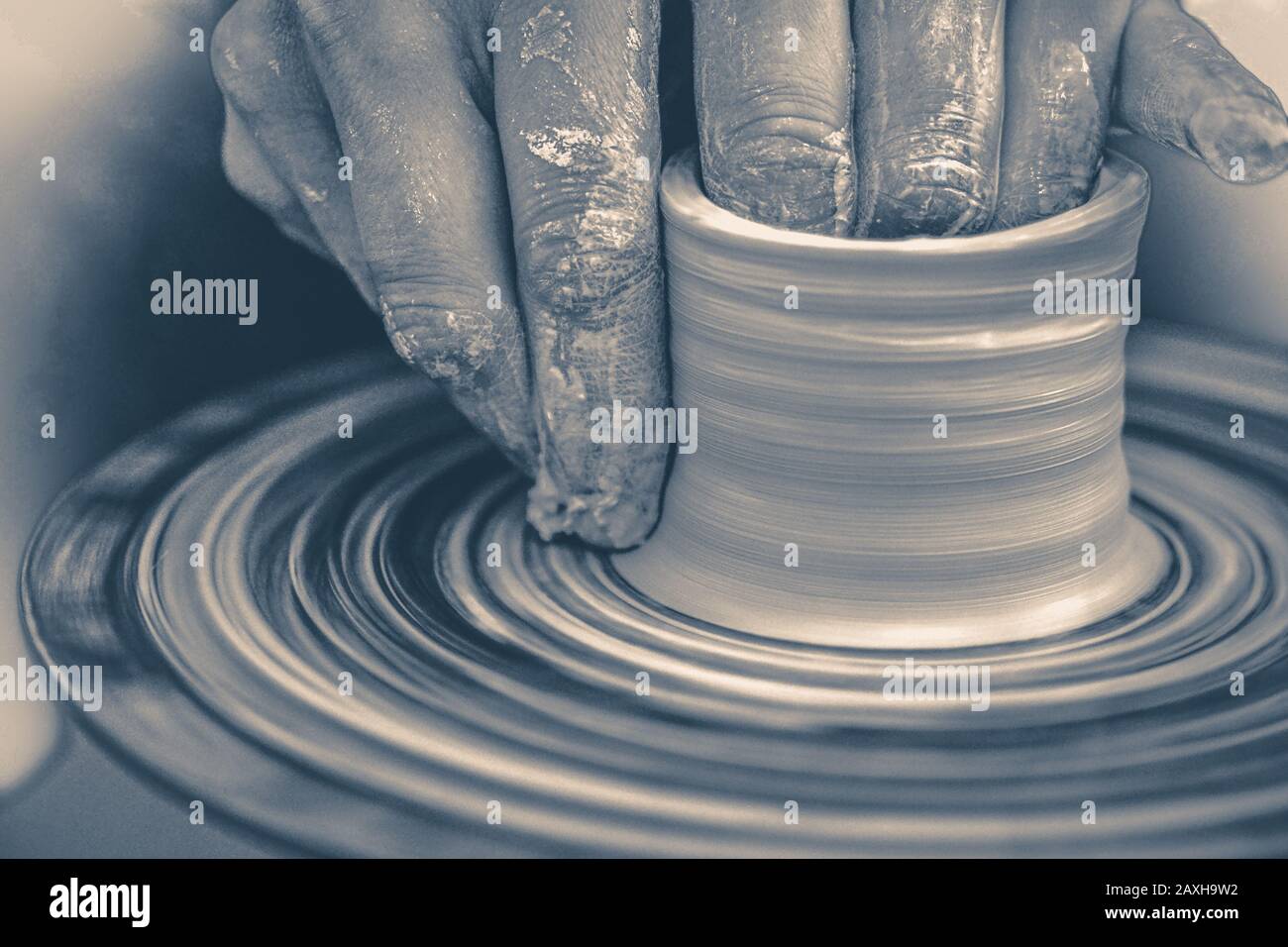 Old vintage photo. The potter molds clay jug pot closeup. Monochrome