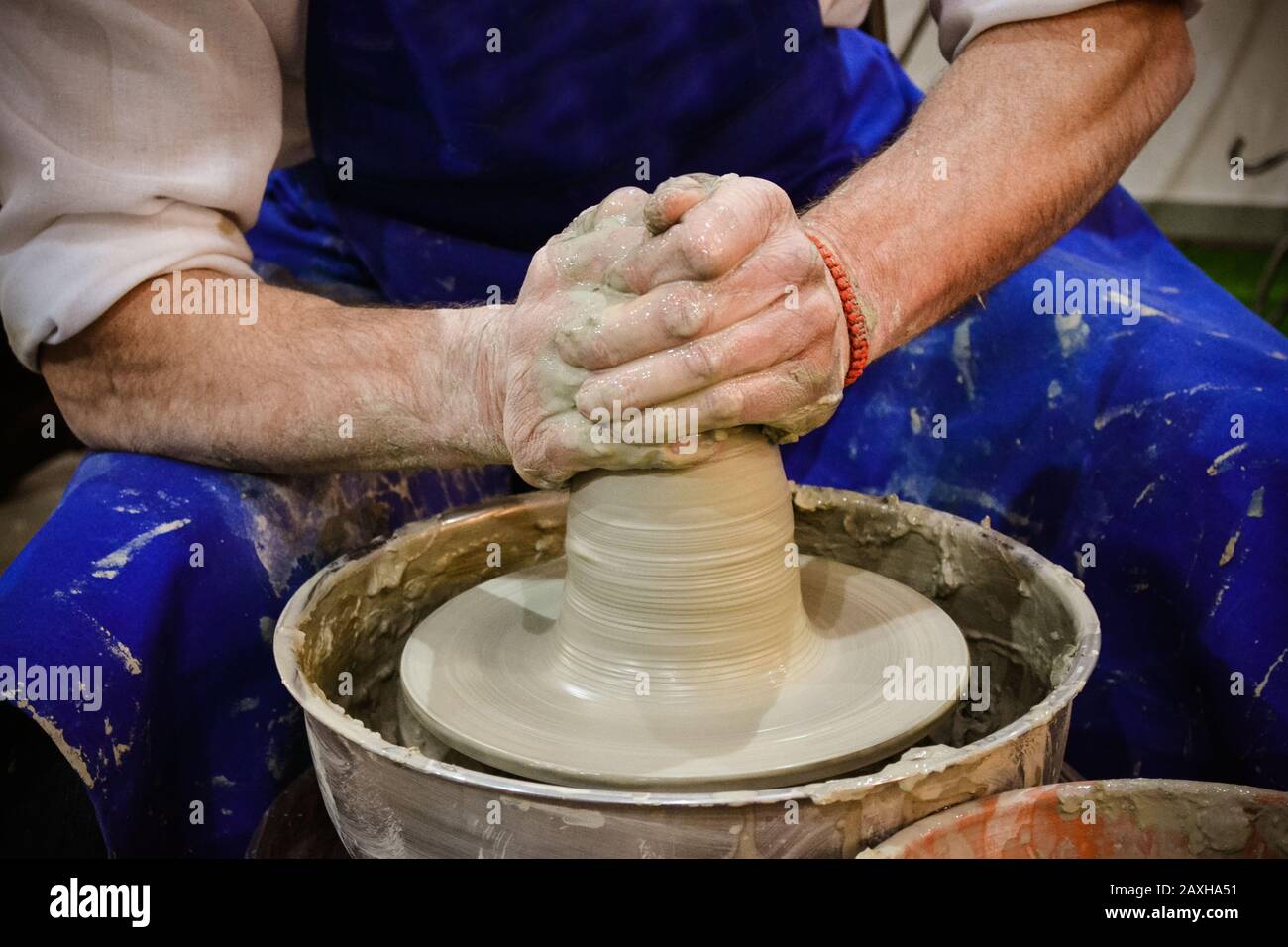 The potter molds clay jug pot closeup. Workshop on sculpt white clay closeup. Dirty hands in the clay. Making ceramic products . Artistic creative. Stock Photo