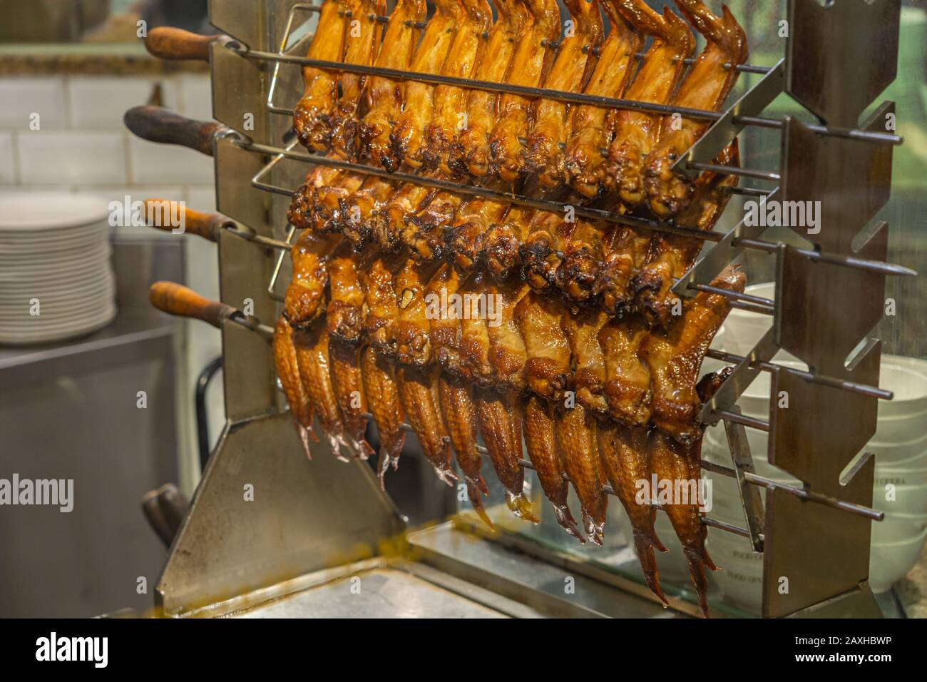 Roasted chicken wings on metal skewers of the grilling machine Stock Photo Alamy
