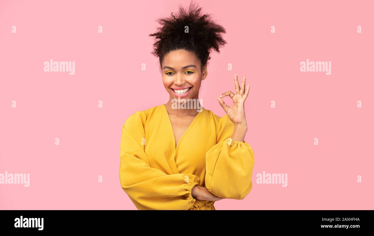 Happy afro woman gesturing ok sign and smiling Stock Photo
