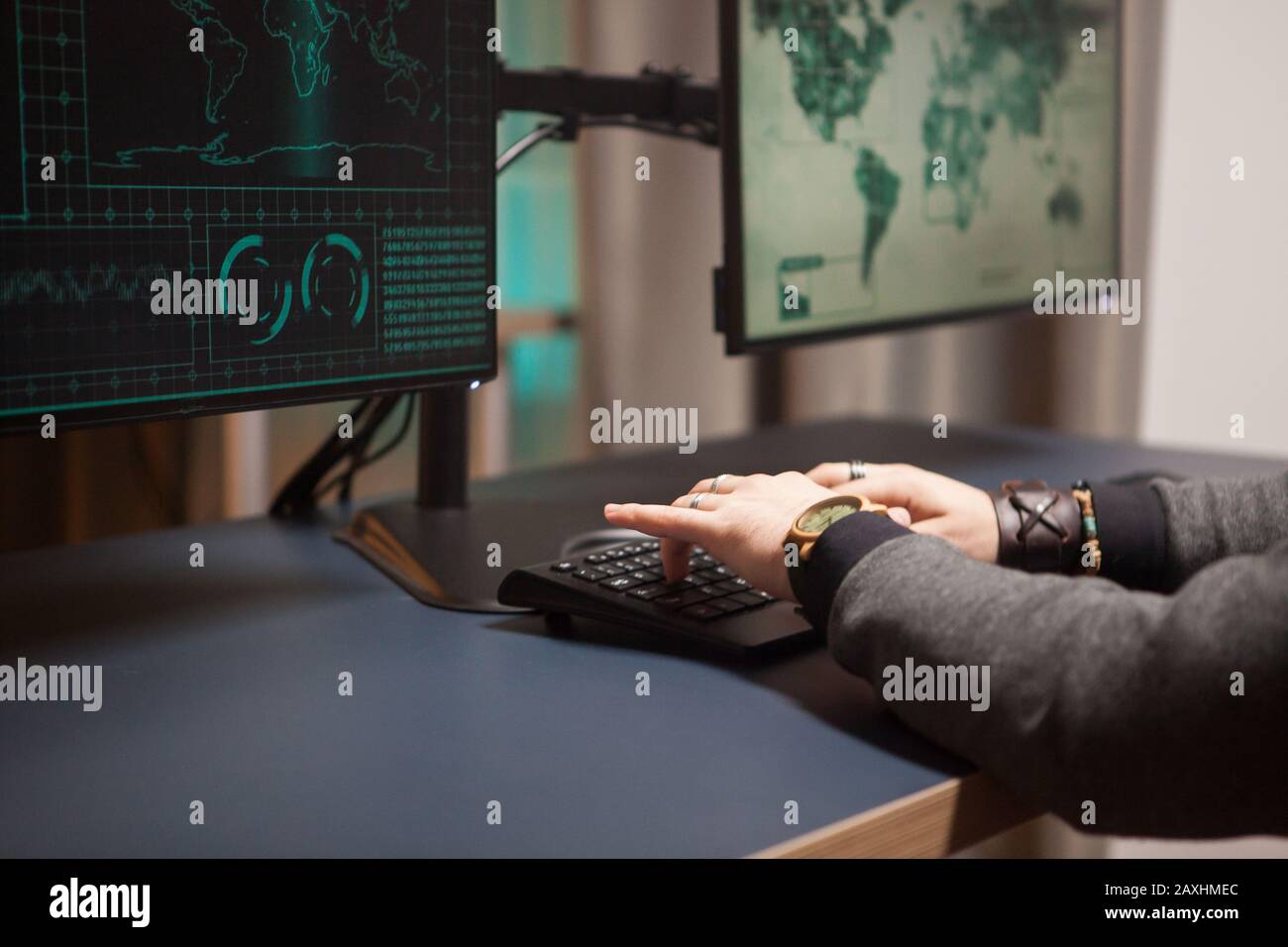 Close up of cyber criminal trying to break a firewall from his computer. Stock Photo
