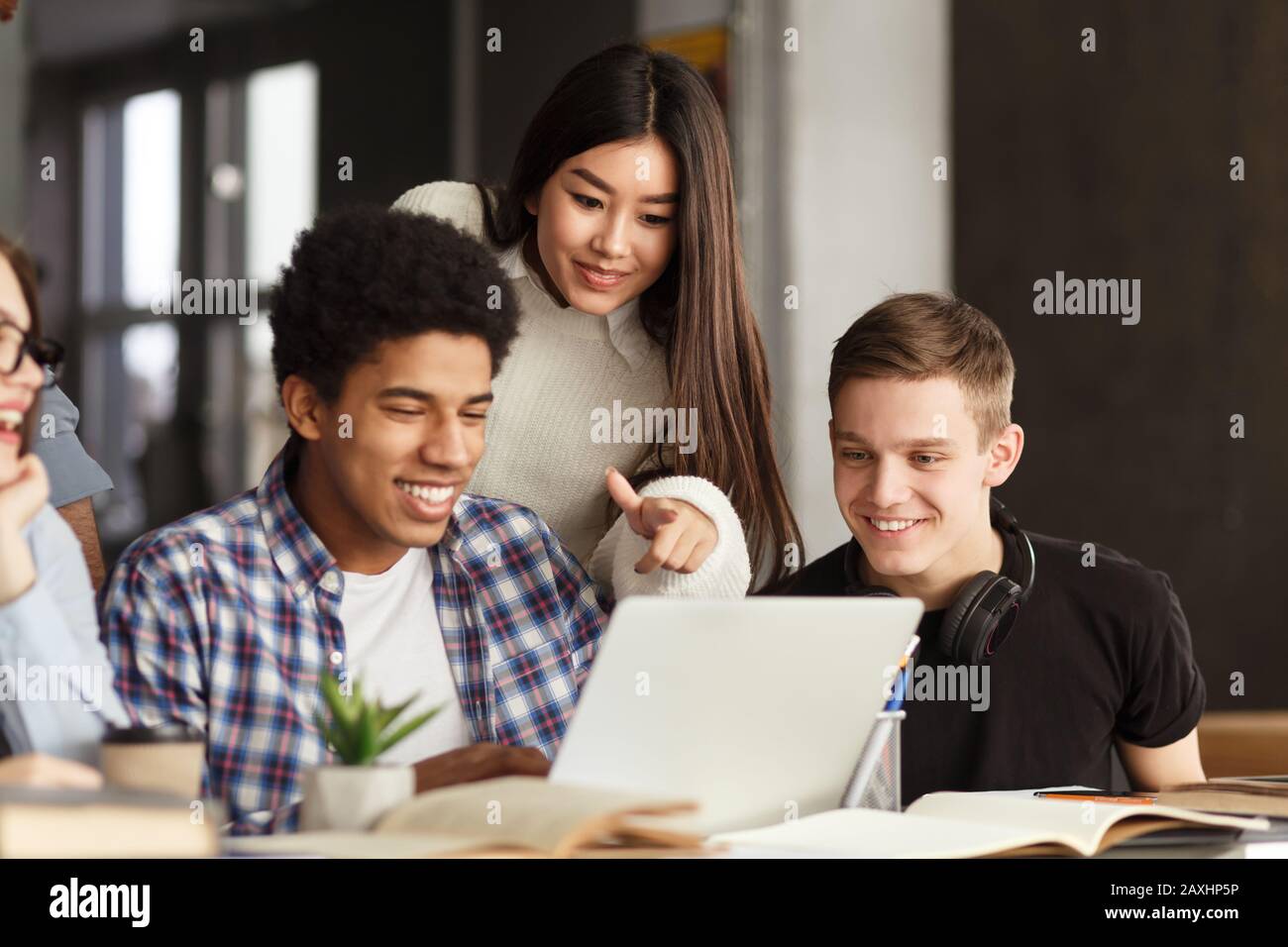 Multinational students talking over project, library interior Stock Photo