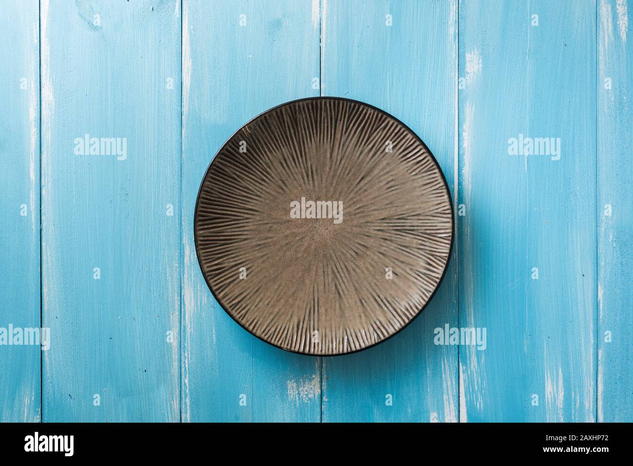 Round Plate on blue wooden table background Stock Photo