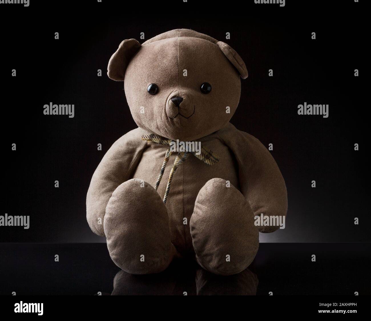 Cute brown childhood teddy bear with black color in the background ...