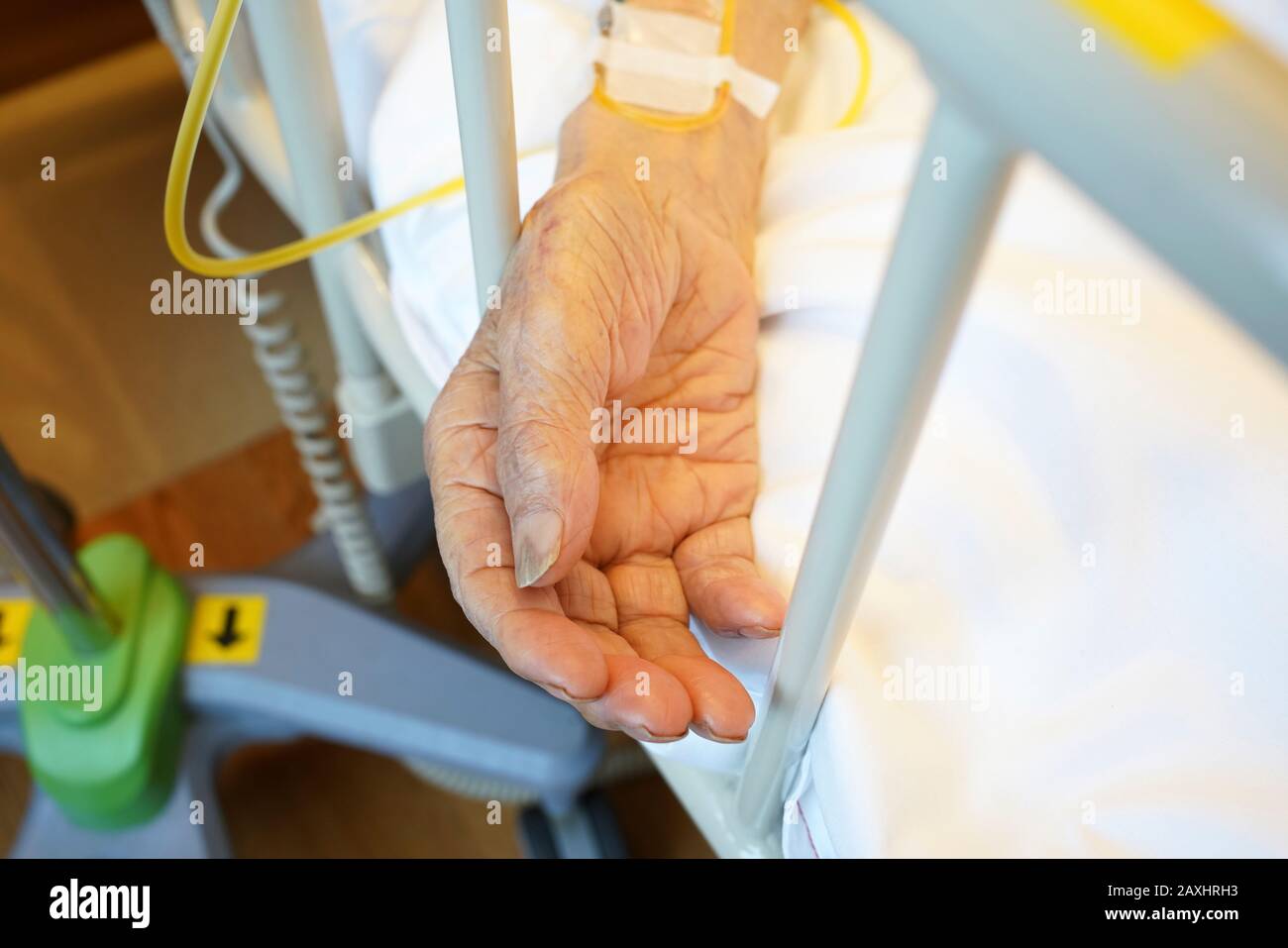 Elderly hands on a wheelchair at home, close up Stock Photo