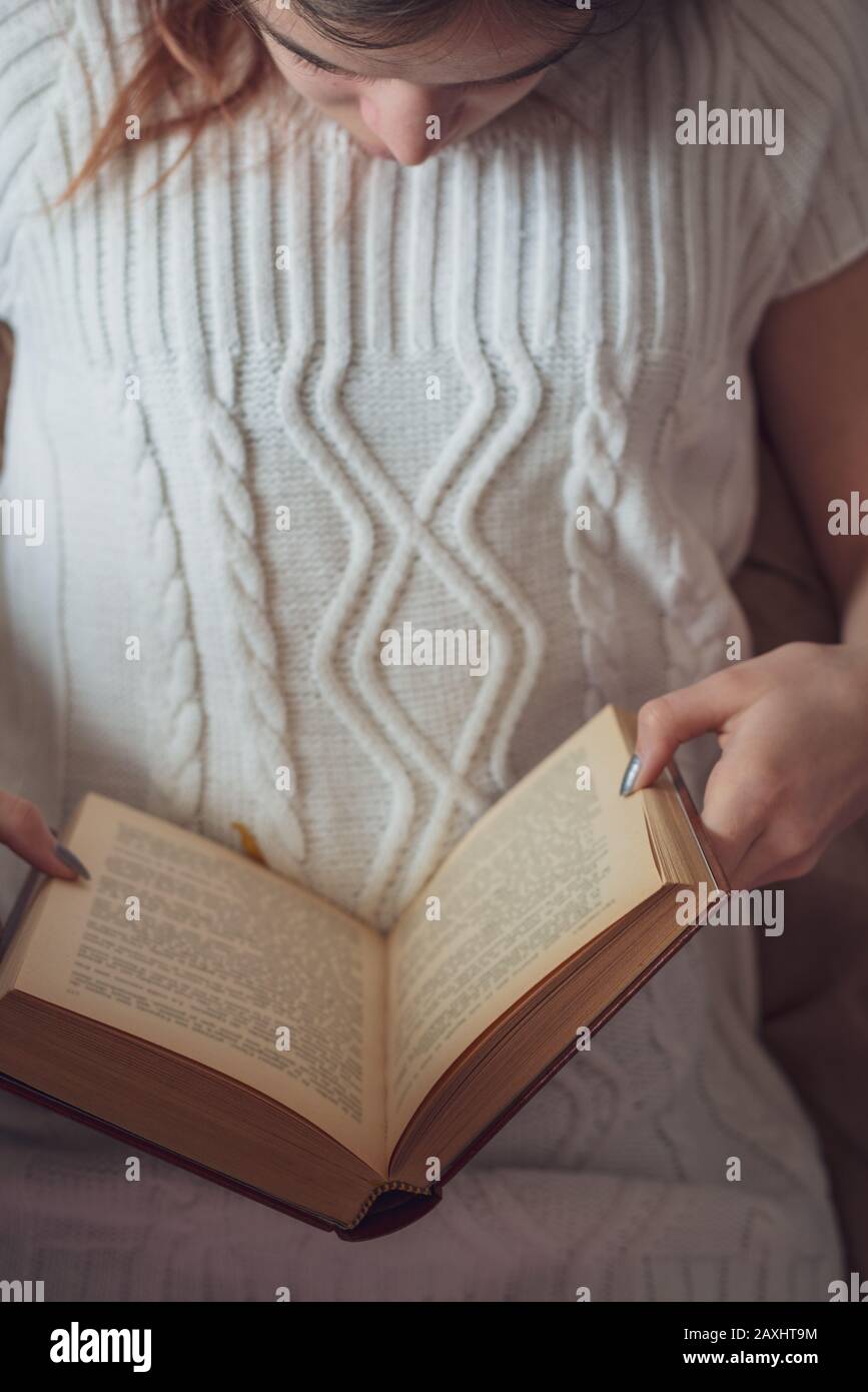 Young girl laying on bed reading , top view concept of cozy weekends & holidays. Stock Photo