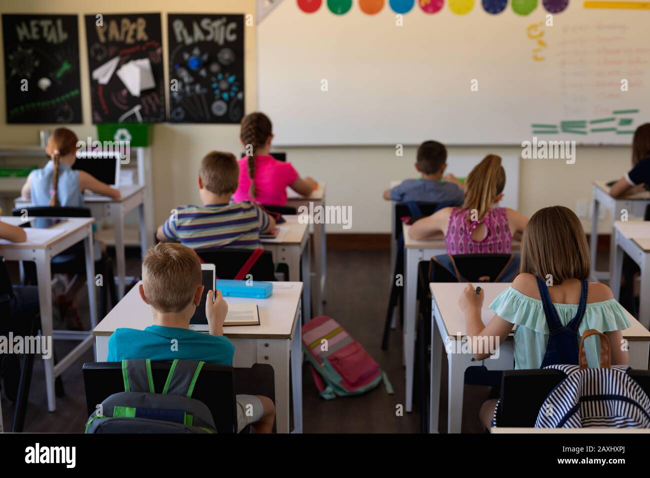 Group of schoolchildren sitting at desks in an elementary school ...