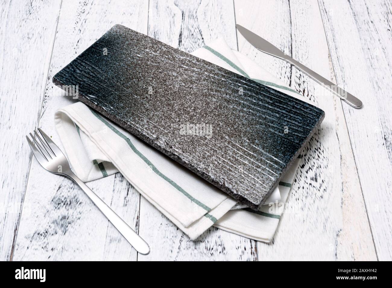 Japanese Plate with utensils and dish towel on white wooden table background side view Stock Photo