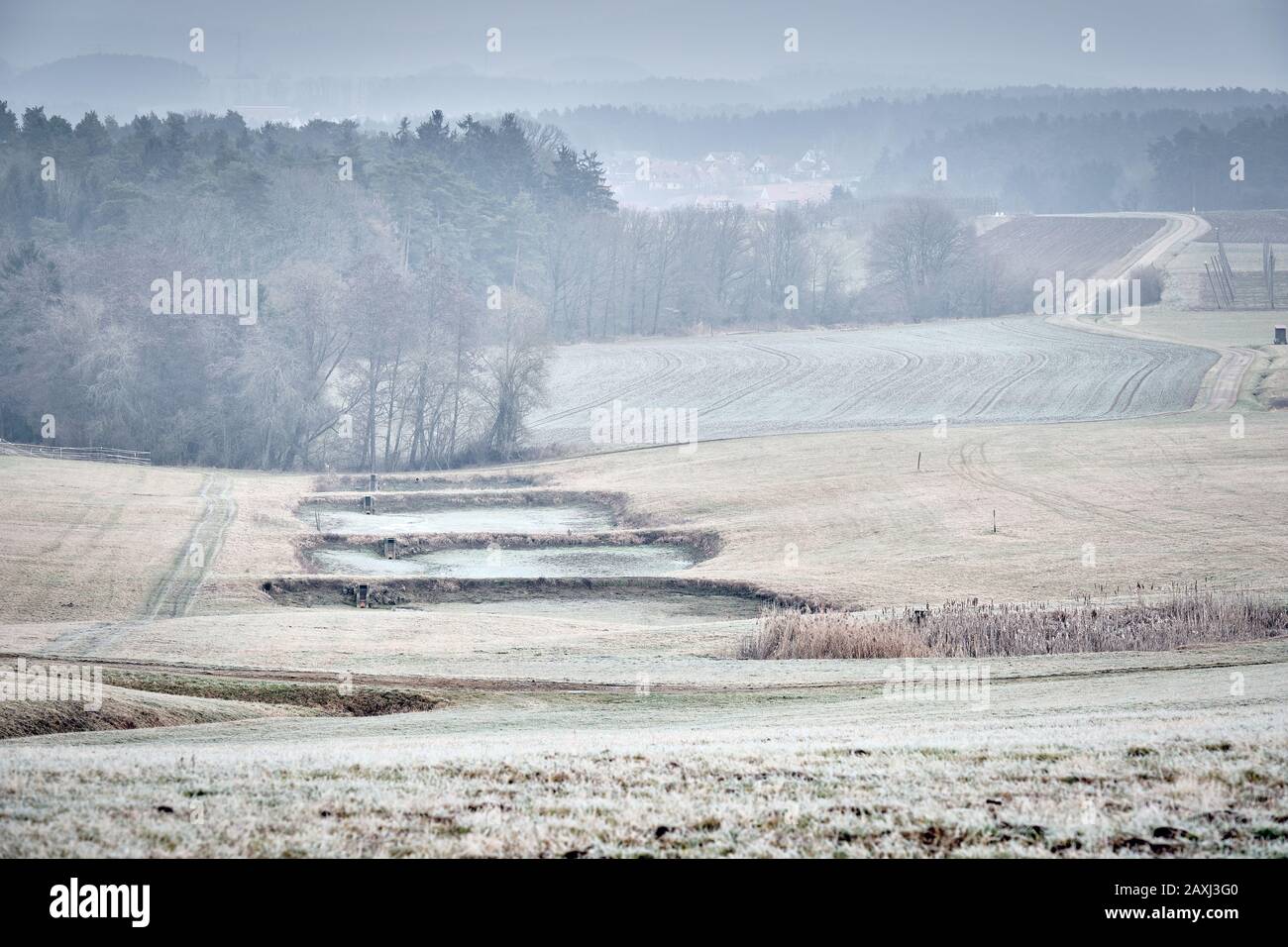 Moody cold countryside winter landscape on a day with dense grey high ...