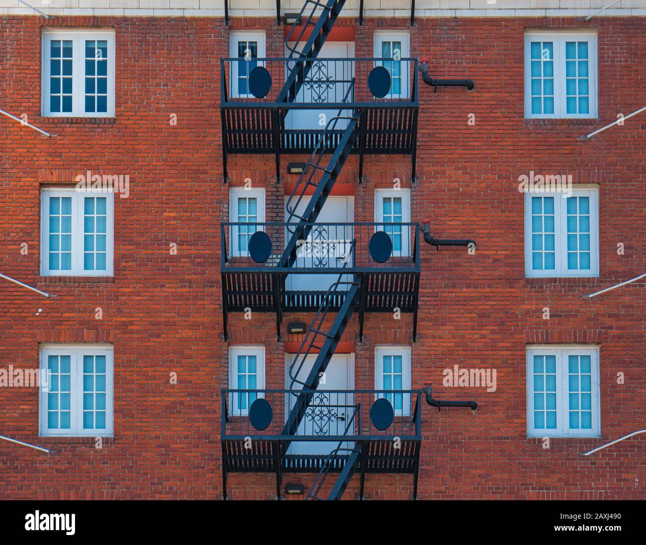 A red brick facade with a black steel emergency staircase Stock Photo