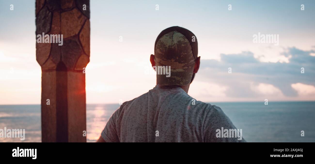 The man looks out over the sea and finds peace. Freedom Concept. Stock Photo