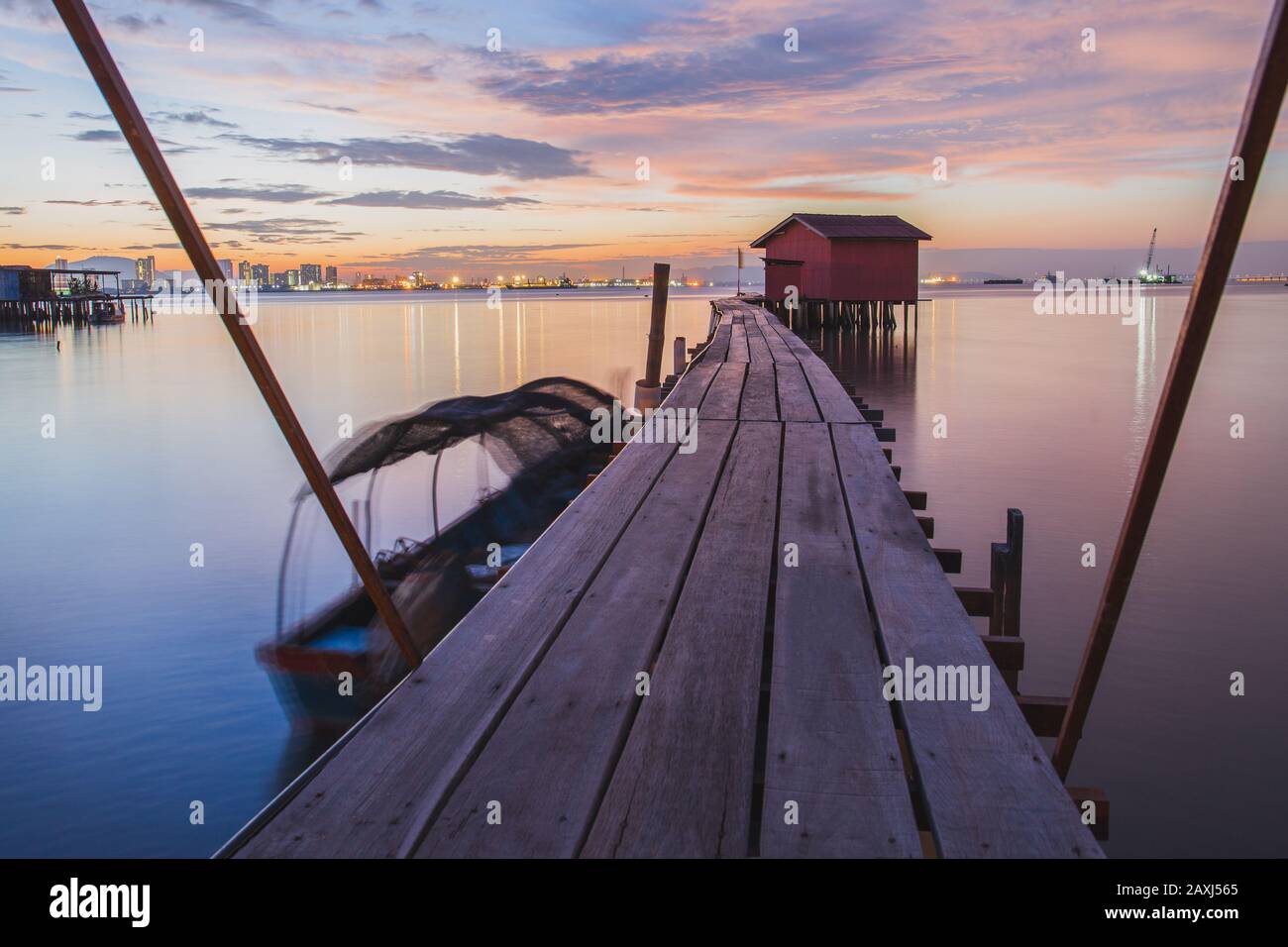 Wooden bridge with hut at sunrise in Chew jetty Georgetown Penang. Stock Photo
