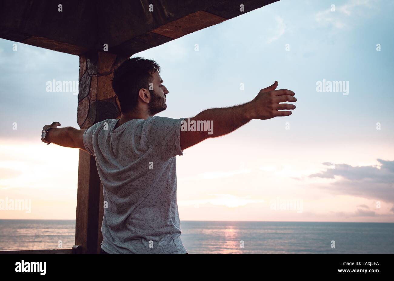 Man who opens his arms to the sea view and finds peace. Freedom Concept