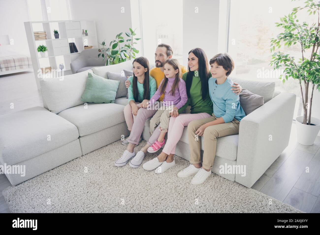 Full dream cozy loving family sit couch daddy mommy sit couch hug embrace her preteen small kids girls boys in house living room Stock Photo