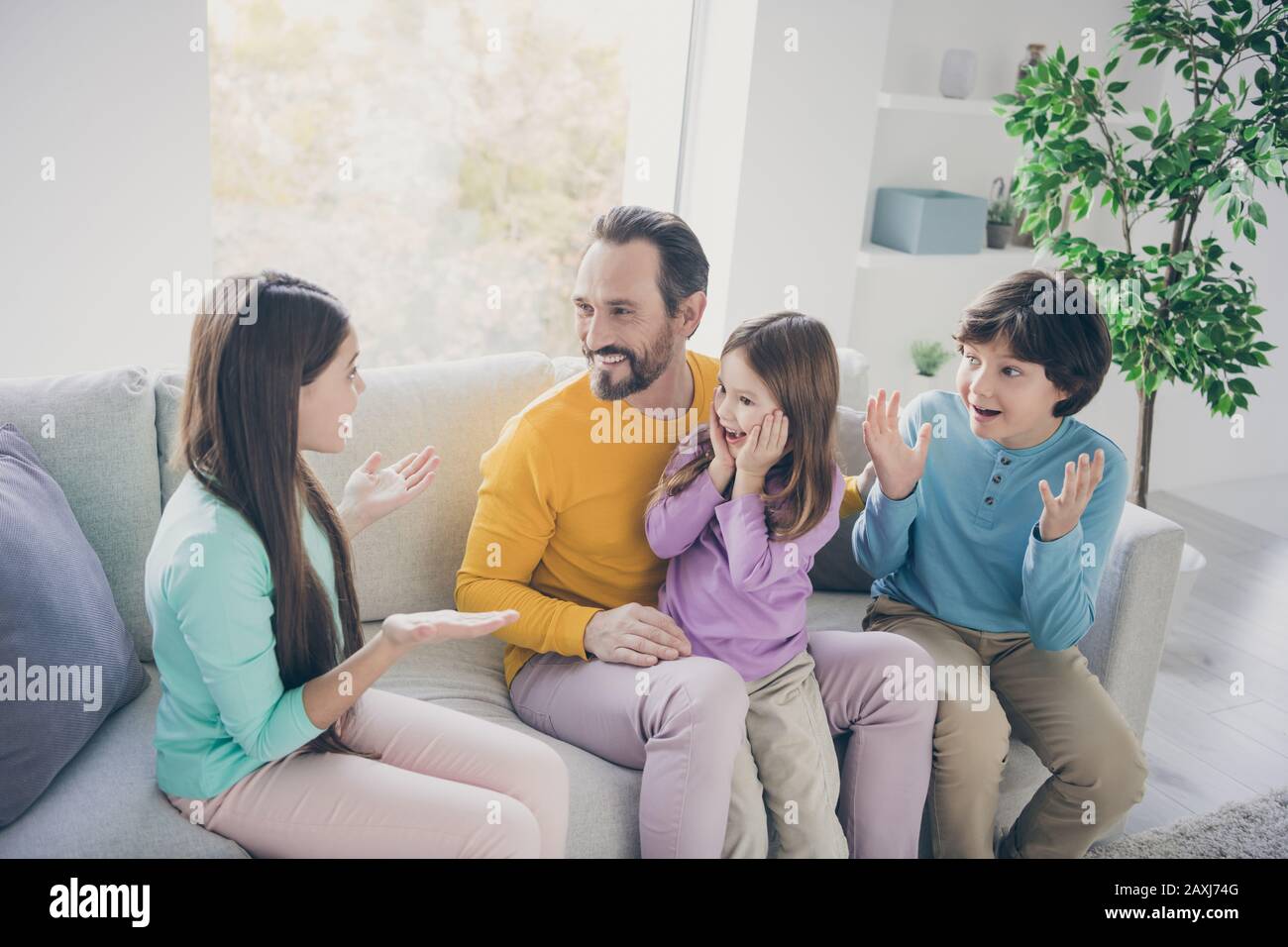 Top above high angle view photo of preteen girl sit couch tell school news her younger sister brother feel surprised scream wow omg dad daddy enjoy Stock Photo