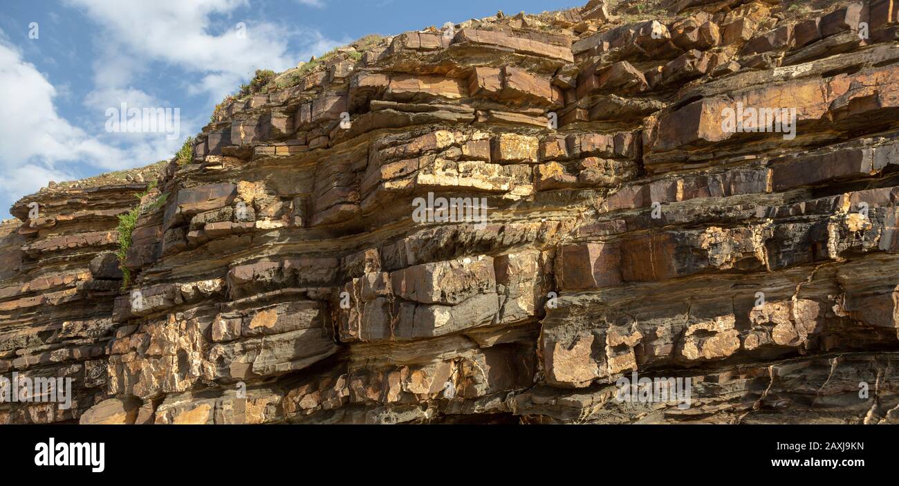 Tilted layers showing bedding planes strata of sedimentary rock coastal