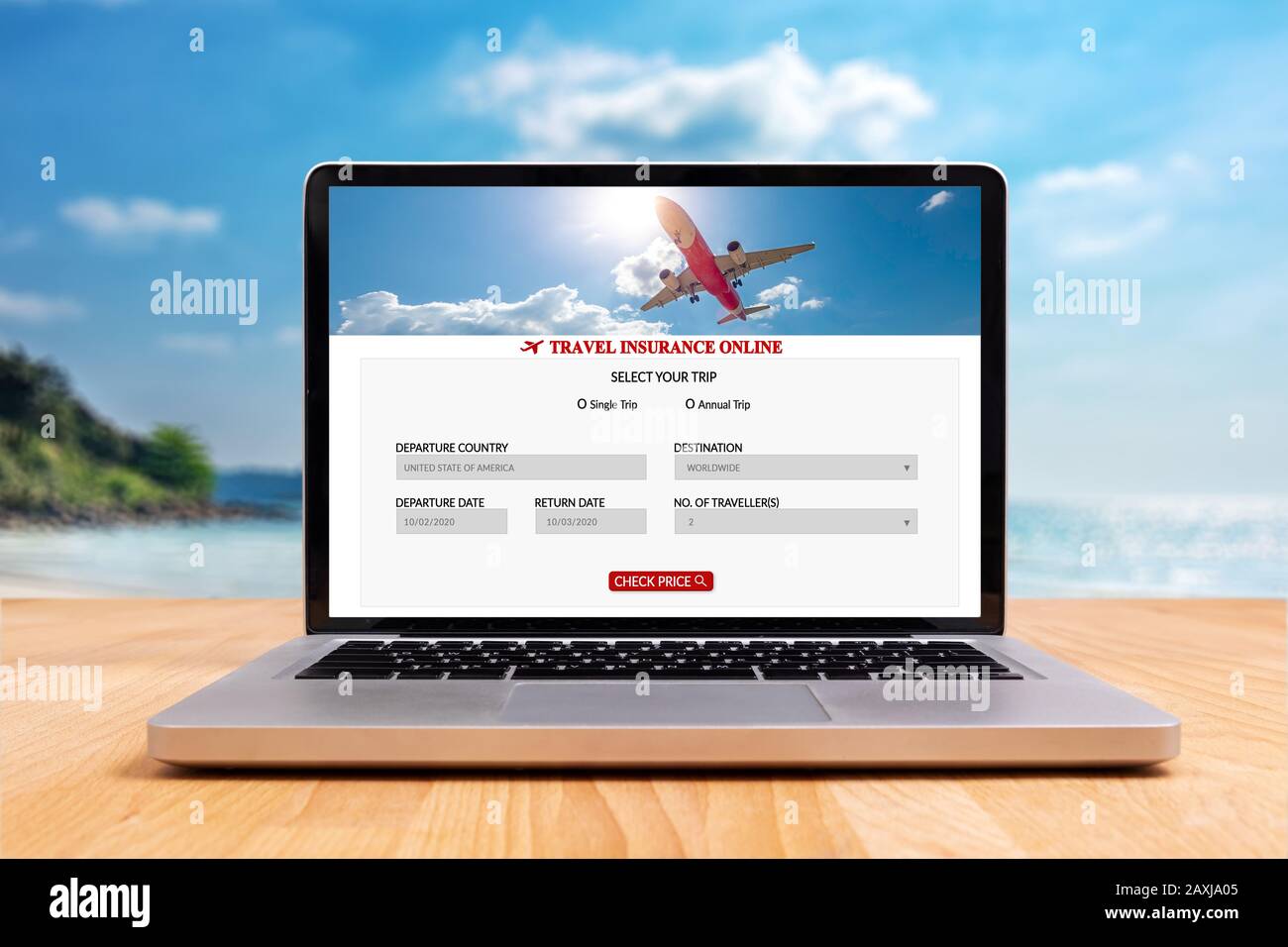 travel insurance online application website screen on laptop computer on wooden desk with blurry summer sea ocean beach at background. online travel i Stock Photo