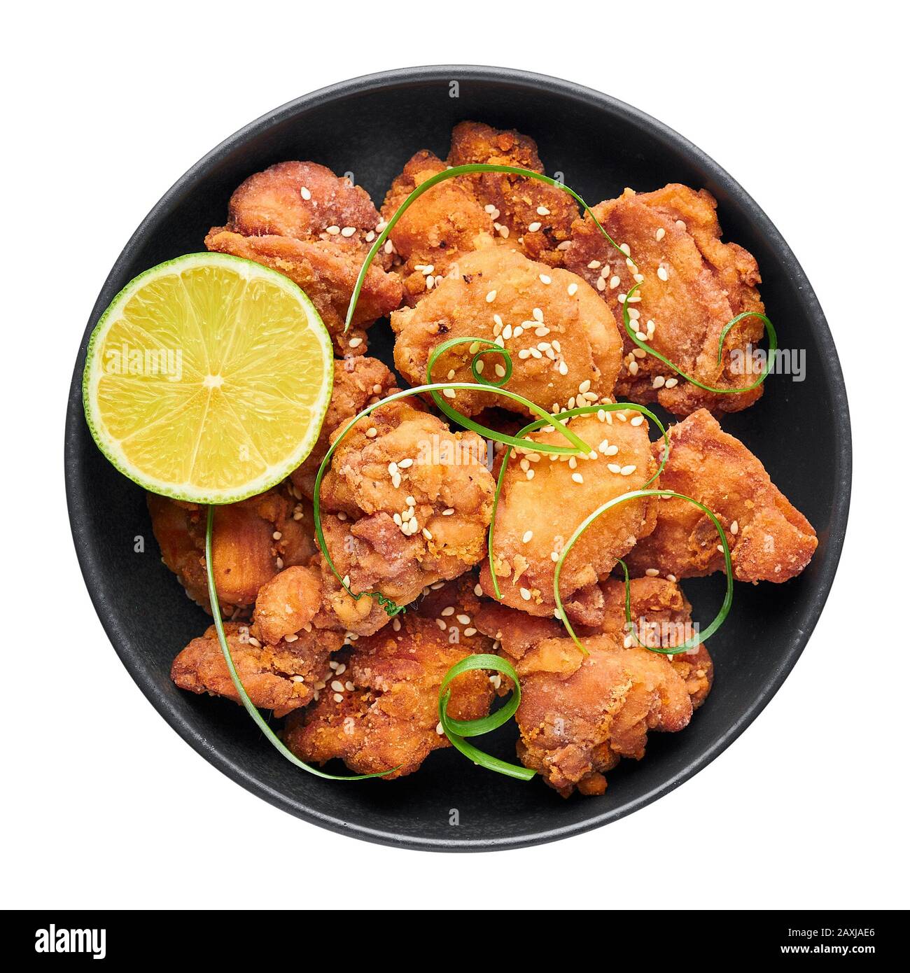 Chicken Karaage in black bowl isolated on white background. Karaage is traditional japanese cuisine dish with deep fried marinated chicken. Stock Photo