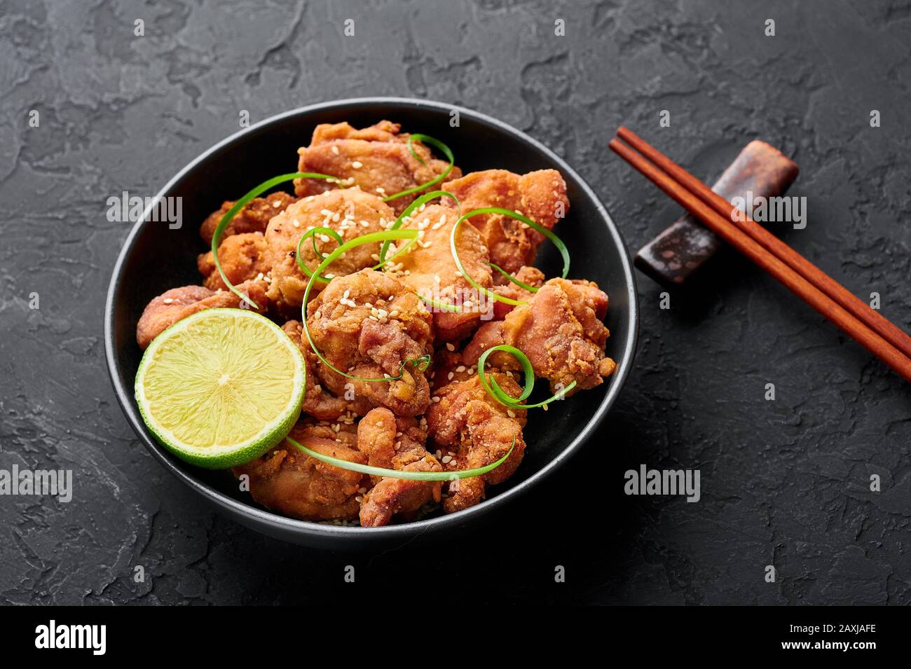 Chicken Karaage in black bowl at dark slate background. Karaage is traditional japanese cuisine