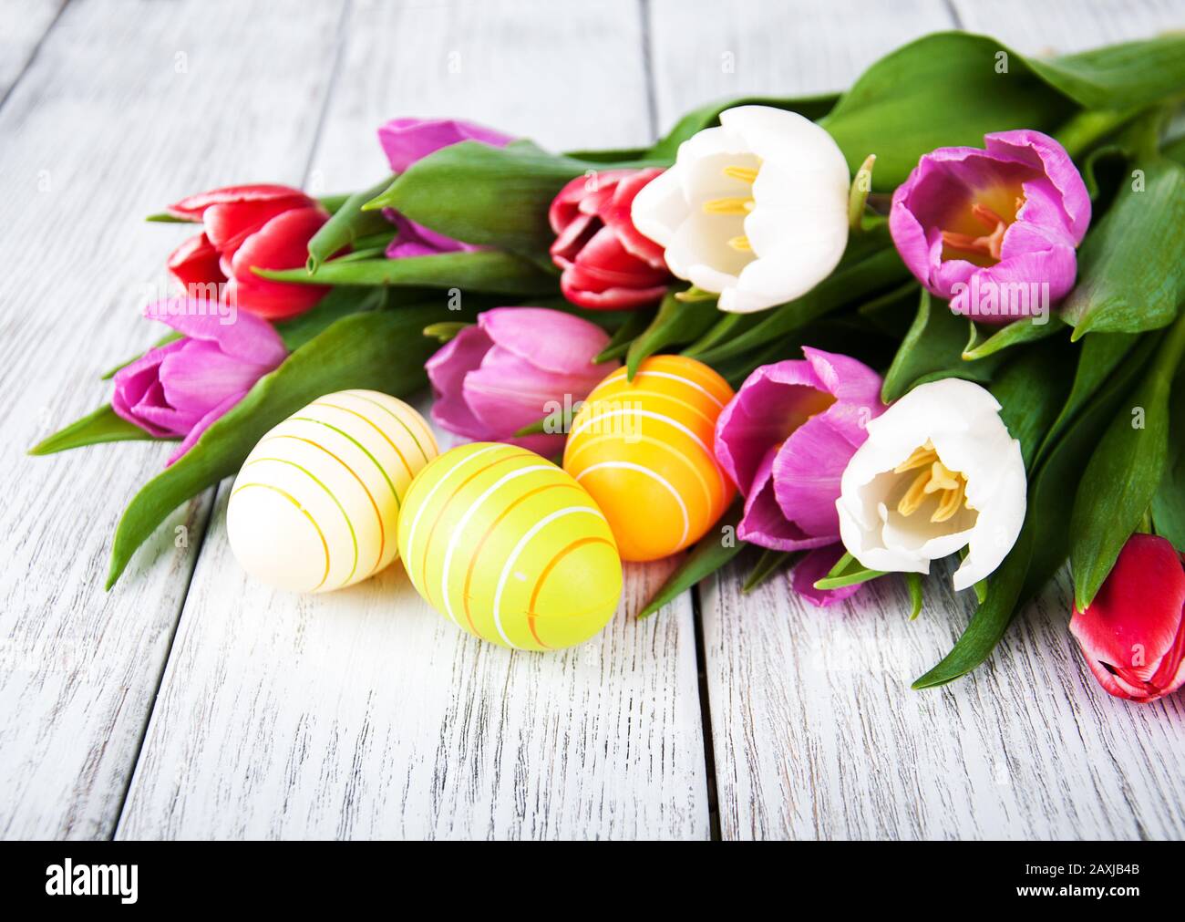 Easter eggs and tulips on a wooden table Stock Photo - Alamy