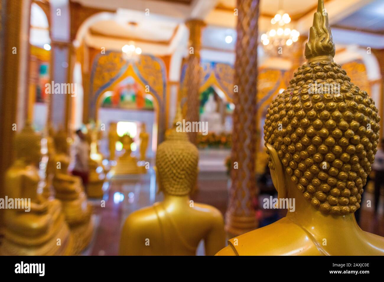 Wat Chalong,Phuket/Thailand-15December2019: Detail shot inside the first floor of the grand pagoda with statues in gold of lord buddha praying Stock Photo
