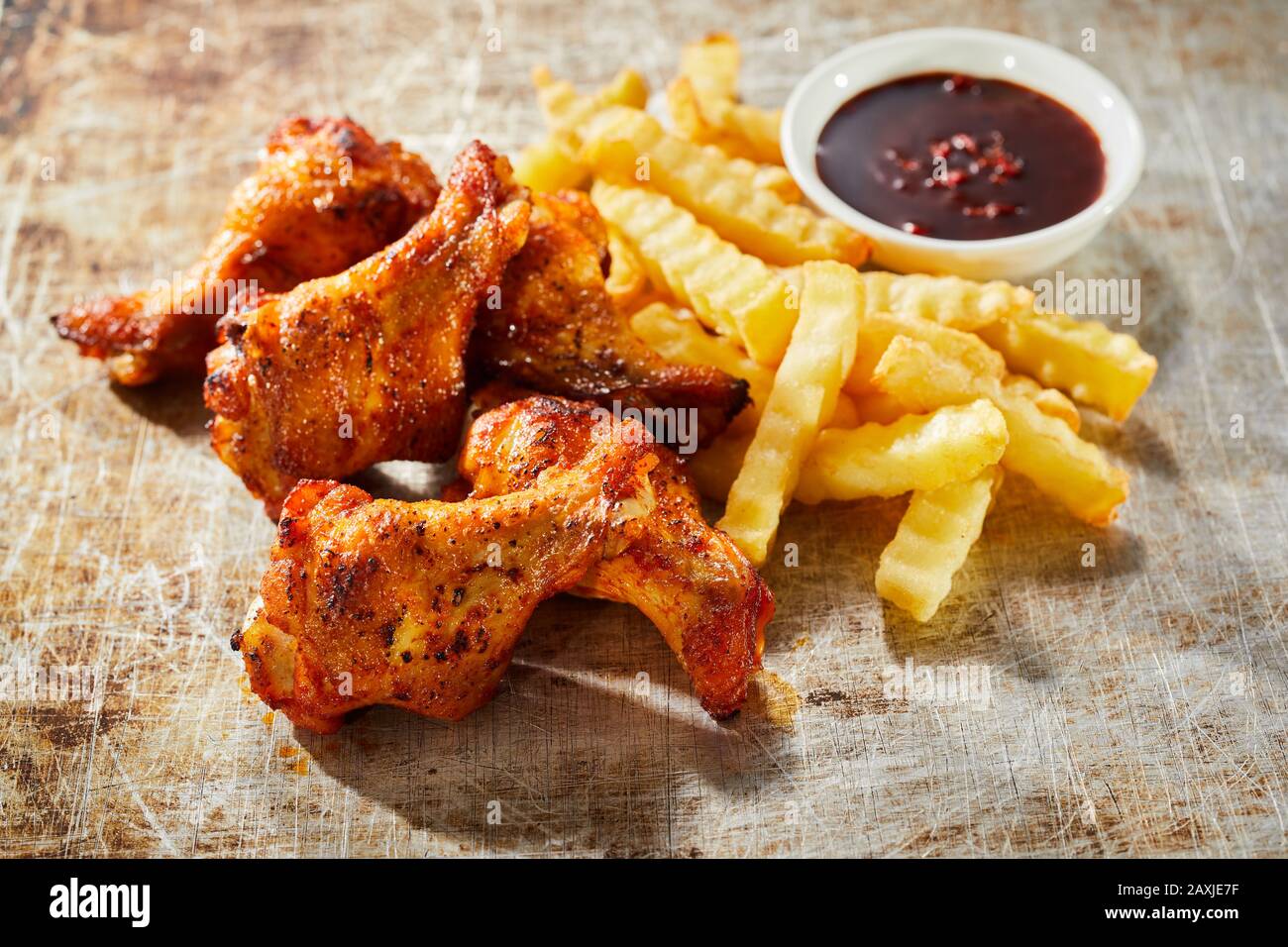Tasty snack of grilled spicy chicken wings served with crinkle cut
