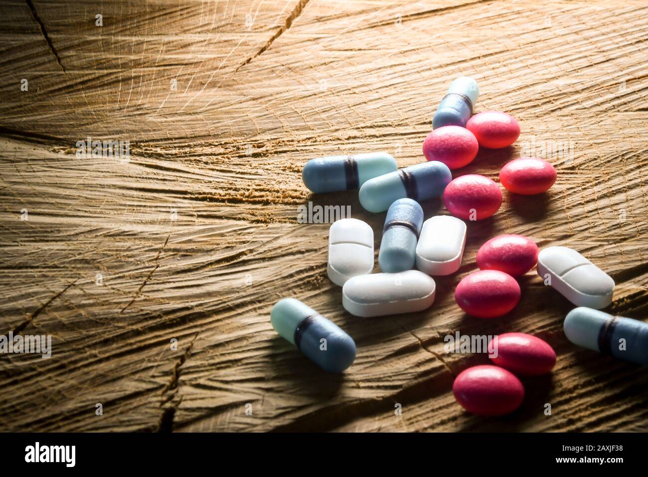 a pile of mixed tablets on a rustic bit of wood Stock Photo