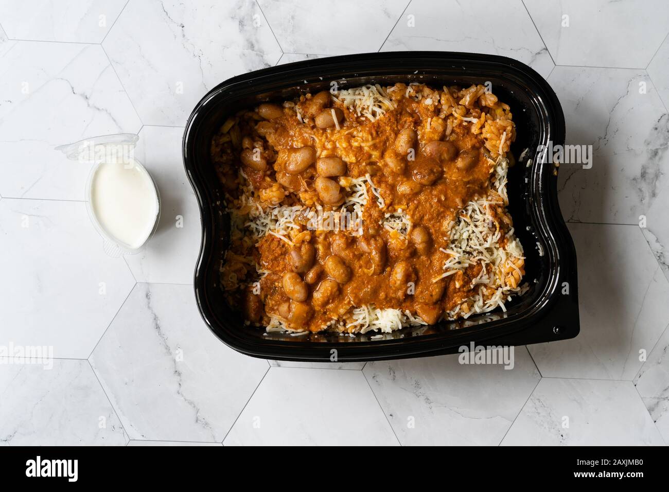 https://c8.alamy.com/comp/2AXJMB0/take-away-mexican-food-rice-with-kidney-bean-sour-cream-grated-mozzarella-cheese-and-salsa-sauce-pilaf-in-plastic-container-box-package-ready-2AXJMB0.jpg