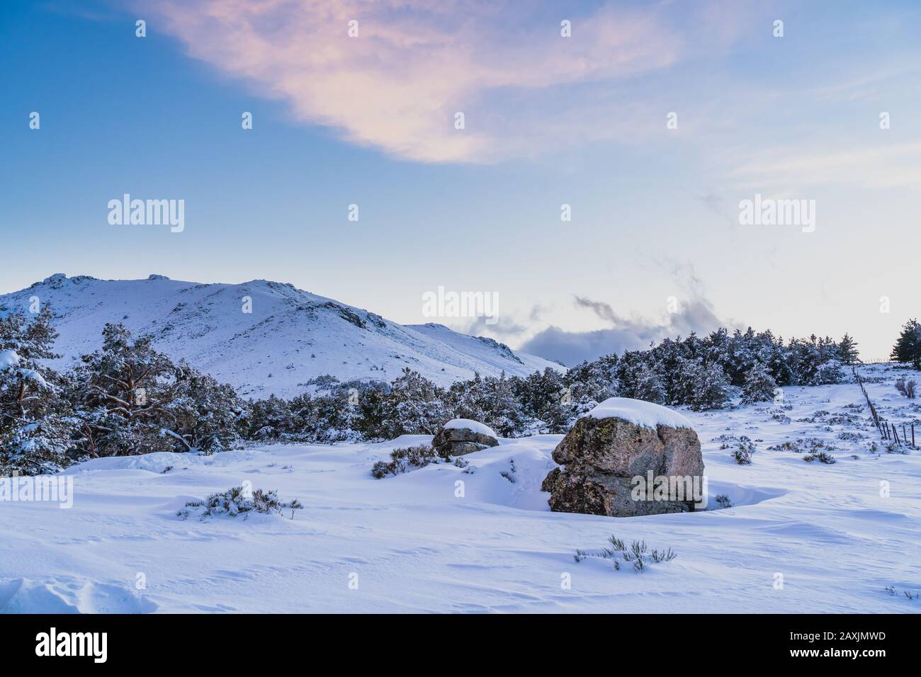 Snowy mountain landscape at sunset, with a rock covered by snow Stock ...
