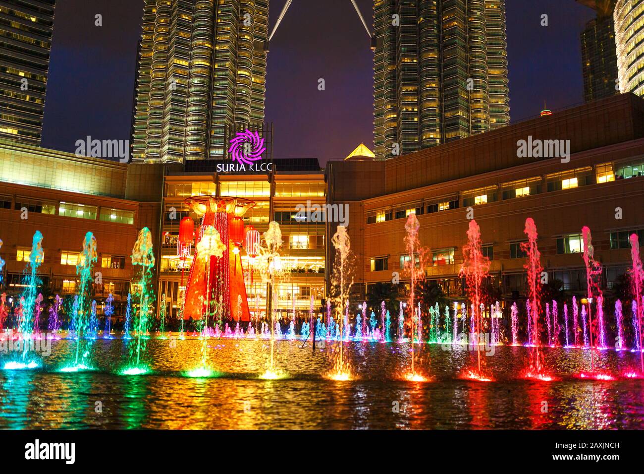 Multicolored dancing fountains near the twin towers of Petronas in