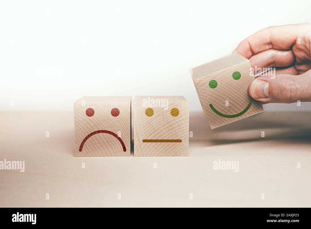 sad, neutral and happy smiling face symbol on wooden blocks, customer satisfaction and service rating concept Stock Photo