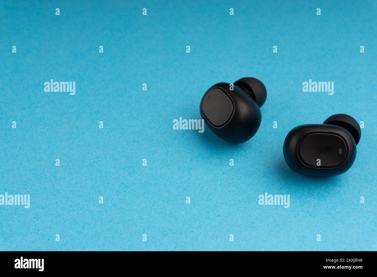 Wireless earbuds or earphones on blue background Stock Photo Alamy