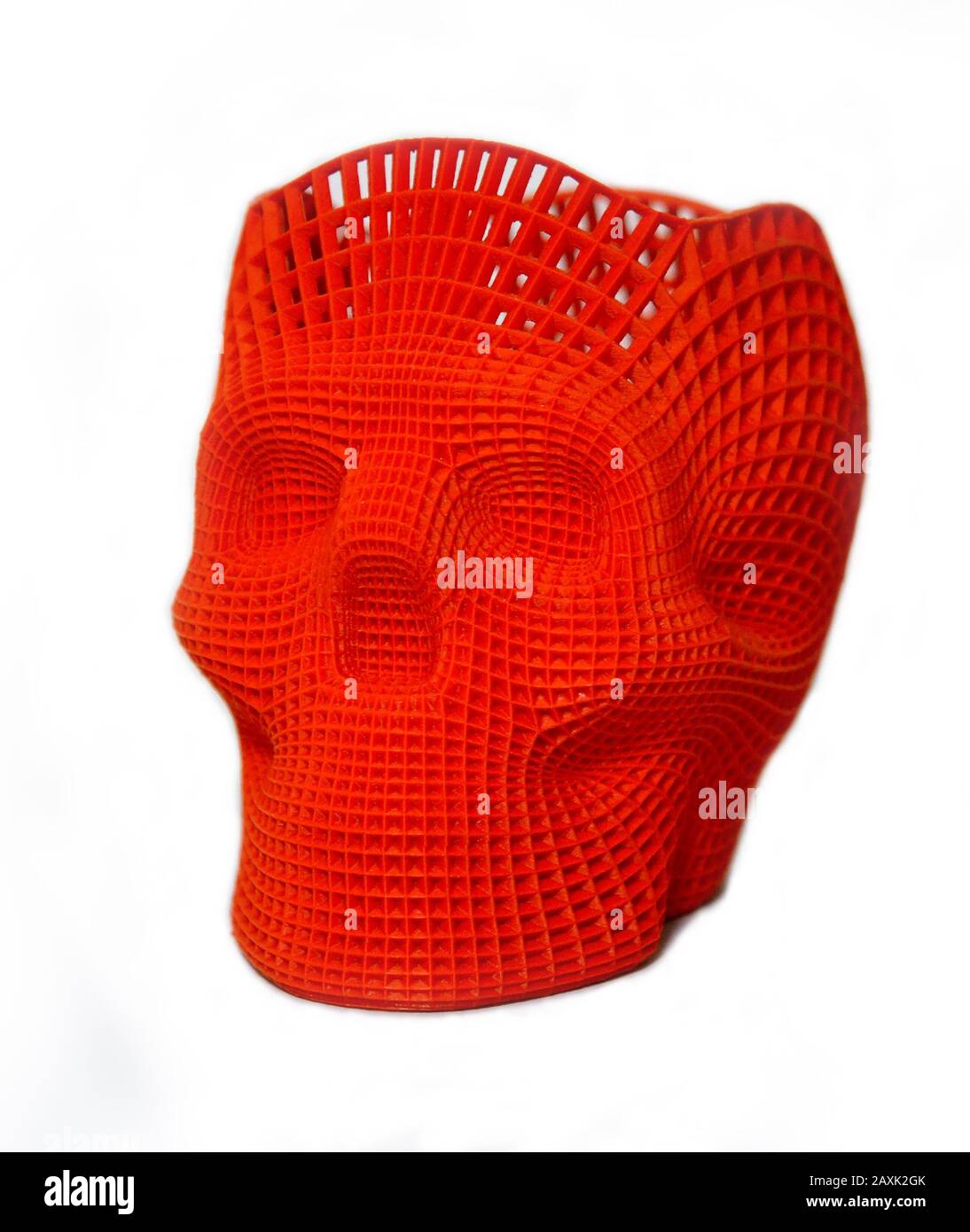 Skull printed with plastic of red color on a 3d printer Isolated on white background. Stock Photo