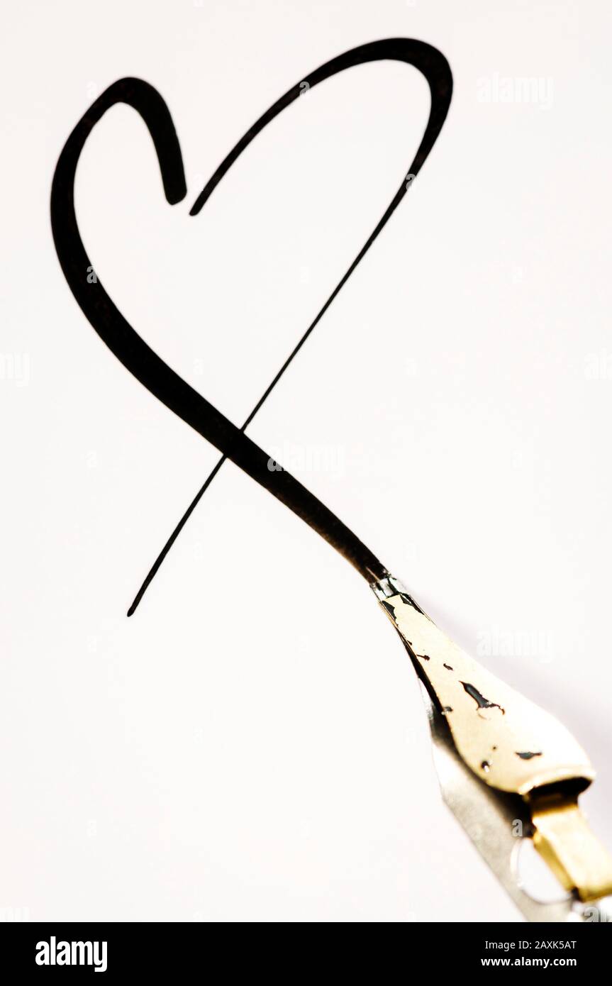 Calligraphy pen finishing a simple black ink heart for a romantic handmade Valentine's Day background Stock Photo