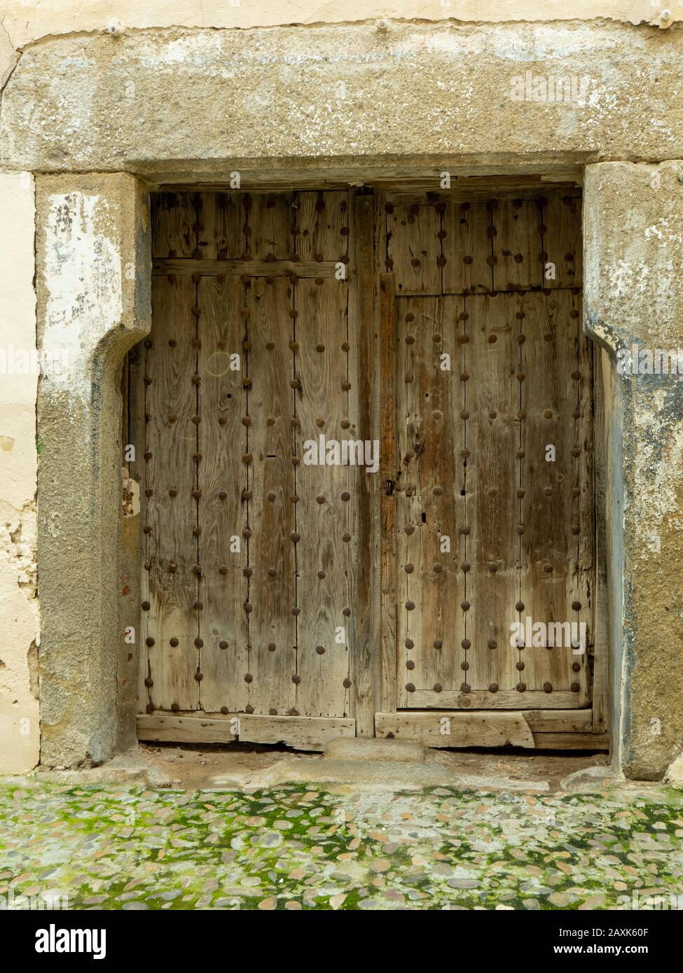Old vintage door  made in wood and iron rivets, stone framed. Talavera de la Reina Stock Photo