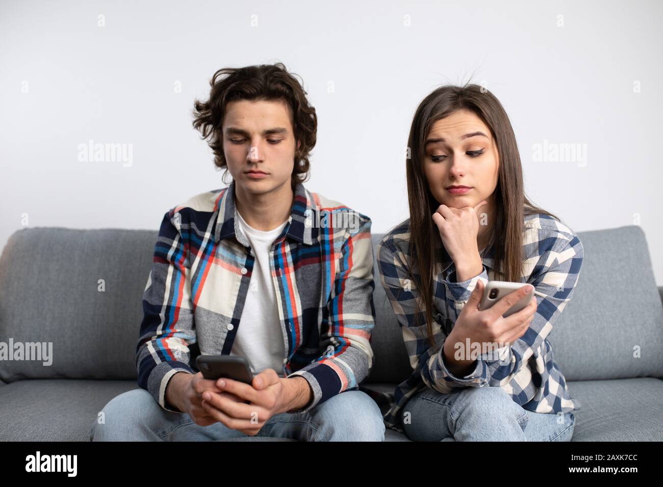 Couple with smartphones faces with relationship difficulties. Stock Photo