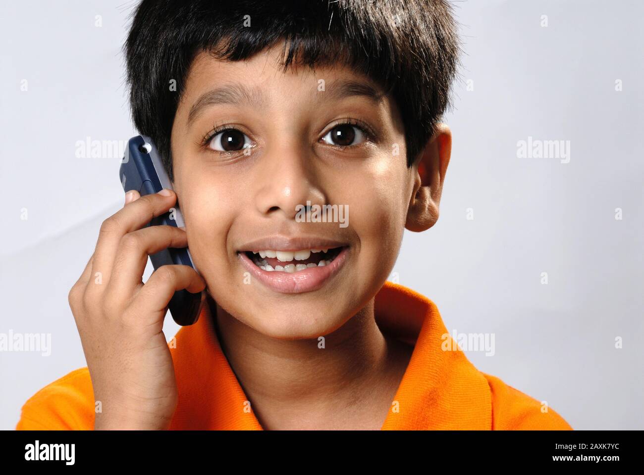 Mumbai, Maharashtra, India- Asia, Supt. 30, 2006 - Indian little cute naughty boy funny expression talking on mobile phone Stock Photo