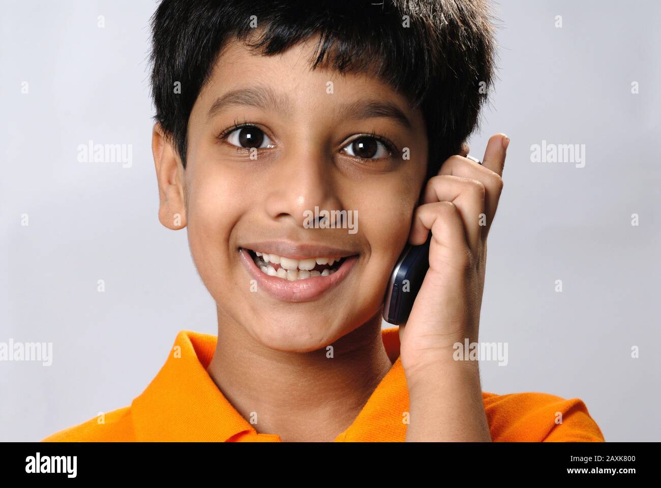 Mumbai, Maharashtra, India- Asia, Supt. 30, 2006 - Indian little cute naughty boy funny expression talking on mobile phone Stock Photo