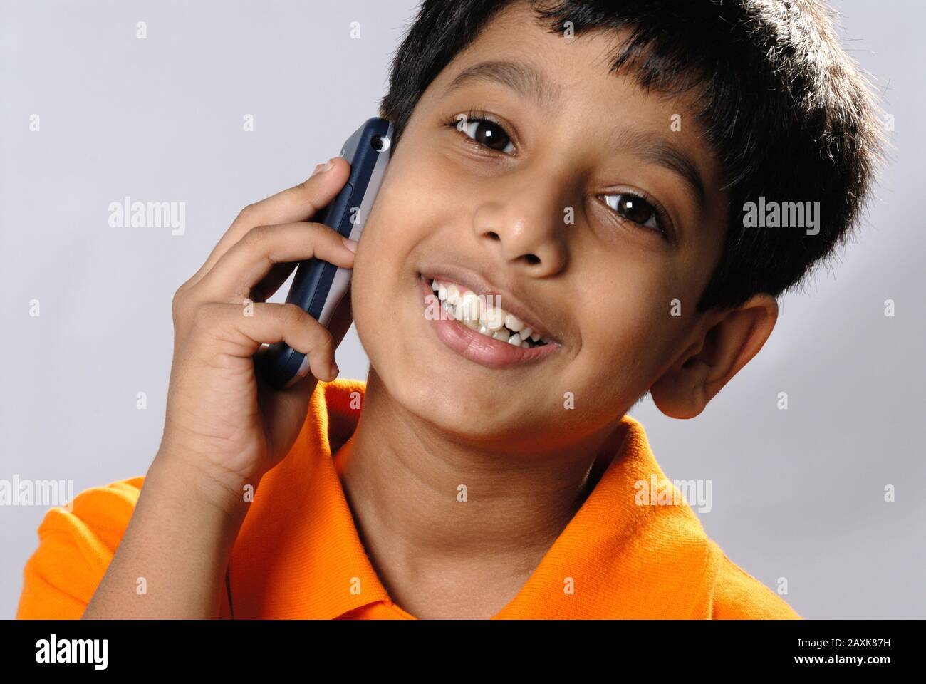 Mumbai, Maharashtra, India- Asia, Supt. 30, 2006 - Indian little cute naughty boy funny expression talking on mobile phone Stock Photo