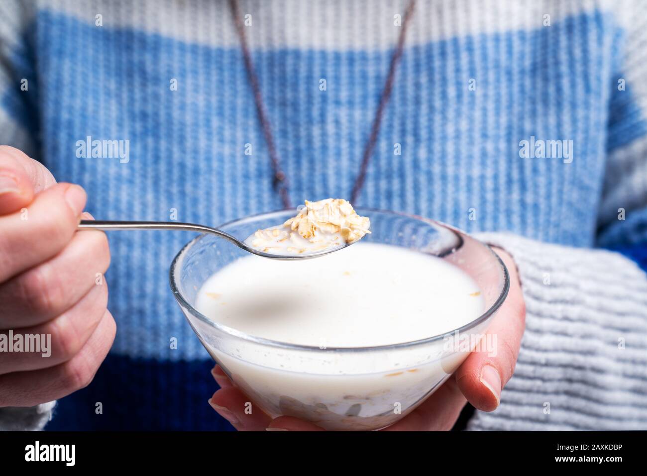 woman is eating a bowl of cereal rolled oats for breakfast. Diet and healthy living concept Stock Photo