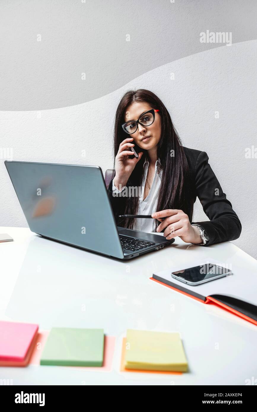 Female boss talking on the phone in the office Stock Photo - Alamy