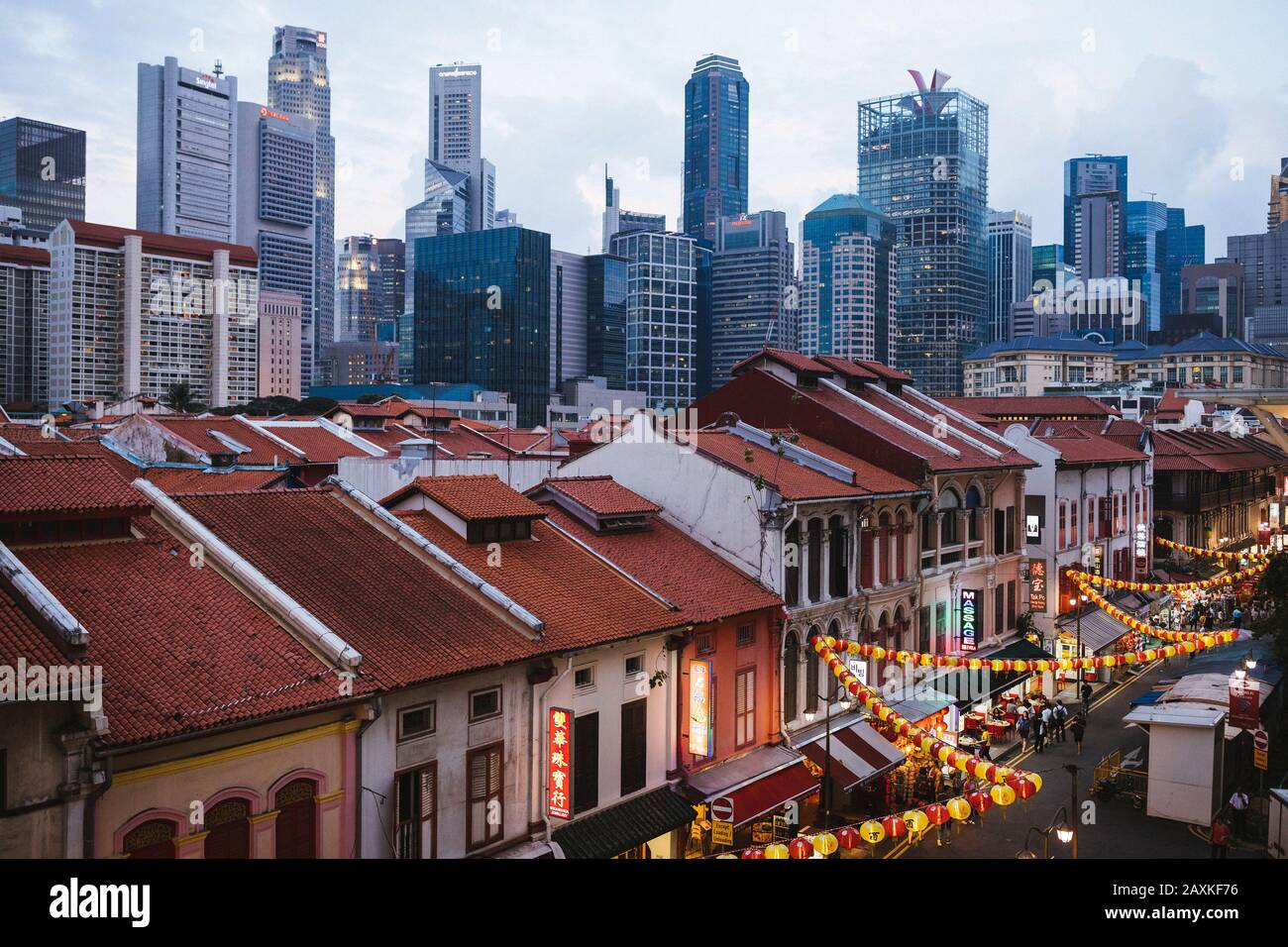 High angle view of old shophouses of Chinatown and the modern skyscrapers of Singapore at dusk. Stock Photo
